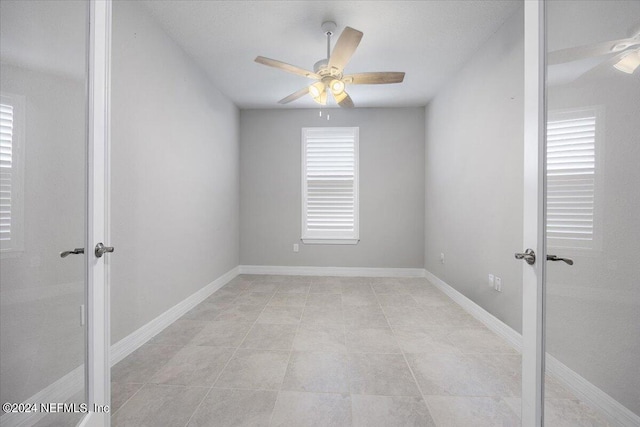 tiled empty room with ceiling fan