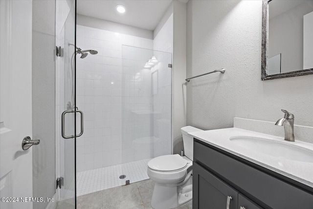 bathroom featuring vanity, tile patterned floors, toilet, and walk in shower