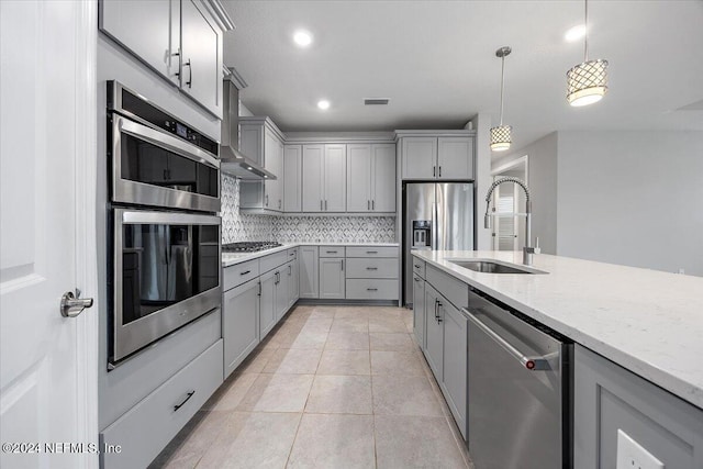 kitchen with decorative backsplash, sink, pendant lighting, gray cabinets, and stainless steel appliances