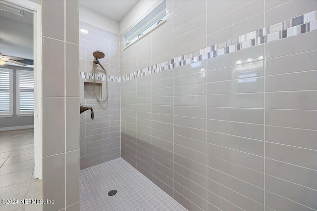 bathroom with a tile shower, ceiling fan, tile patterned floors, and a wealth of natural light