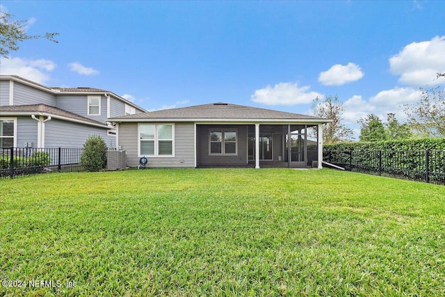 rear view of property with a lawn and a sunroom