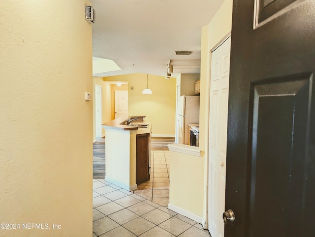 corridor featuring light tile patterned flooring and sink