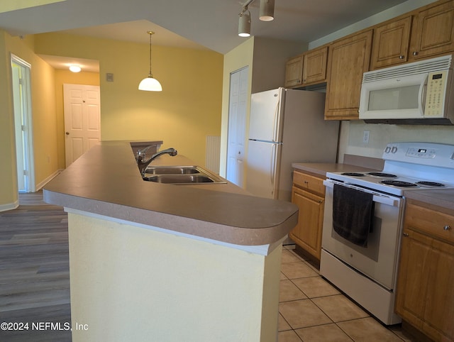 kitchen featuring sink, a center island with sink, and white appliances