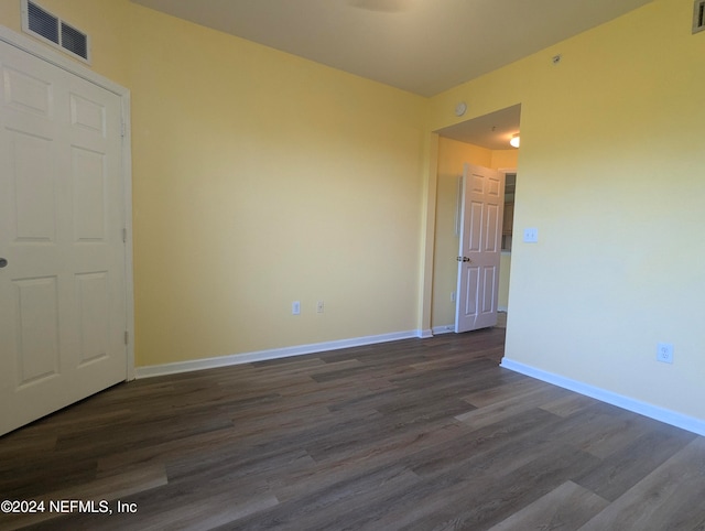 spare room with dark wood-type flooring