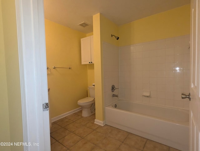 bathroom featuring toilet, tile patterned flooring, and tiled shower / bath