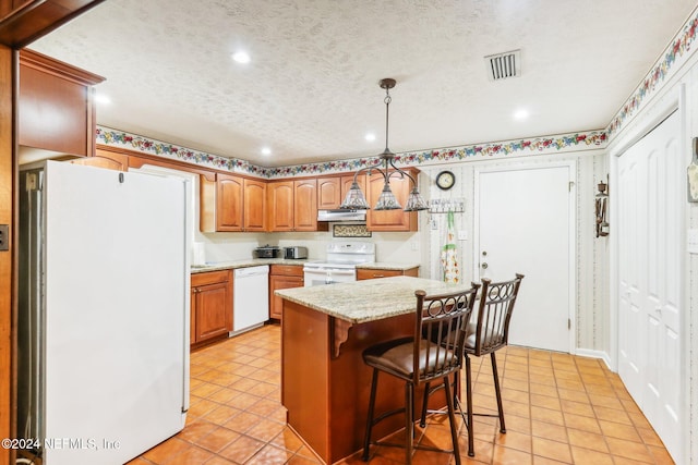 kitchen with a breakfast bar, hanging light fixtures, white appliances, a kitchen island, and exhaust hood