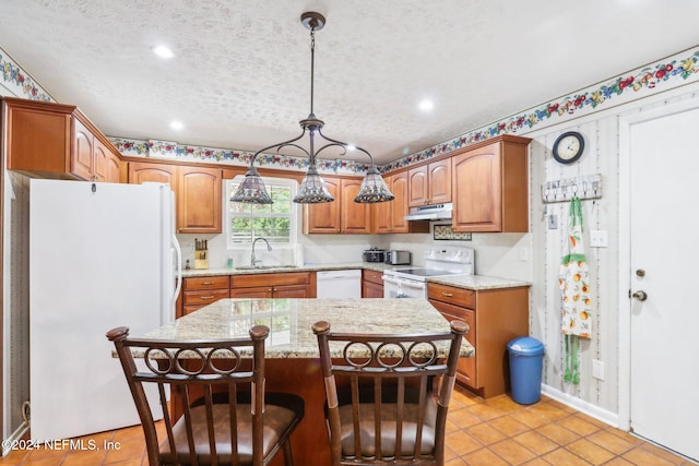 kitchen featuring decorative light fixtures, sink, white appliances, and a kitchen island