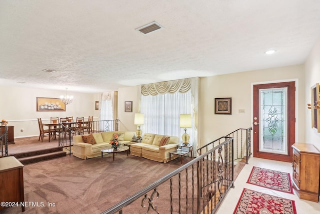 carpeted living room featuring plenty of natural light, a textured ceiling, and an inviting chandelier