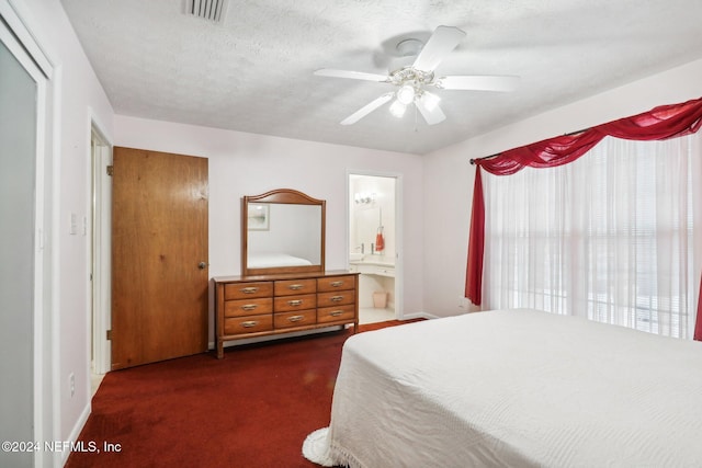 carpeted bedroom featuring connected bathroom, a textured ceiling, and ceiling fan