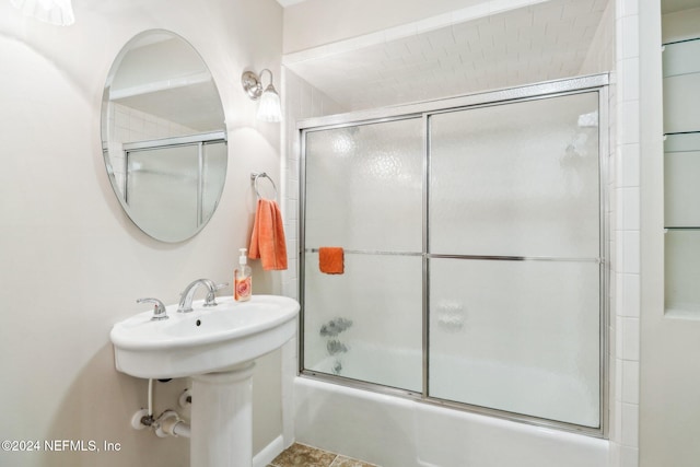 bathroom featuring combined bath / shower with glass door