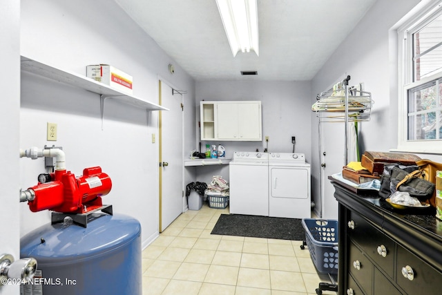 laundry area with washer and clothes dryer, cabinets, and light tile patterned flooring