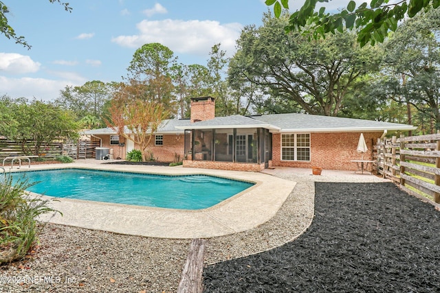 view of pool with a sunroom and a patio area