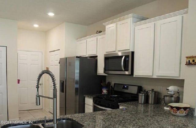 kitchen featuring light tile patterned flooring, recessed lighting, stainless steel appliances, a sink, and white cabinetry