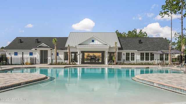 pool with a patio area and fence