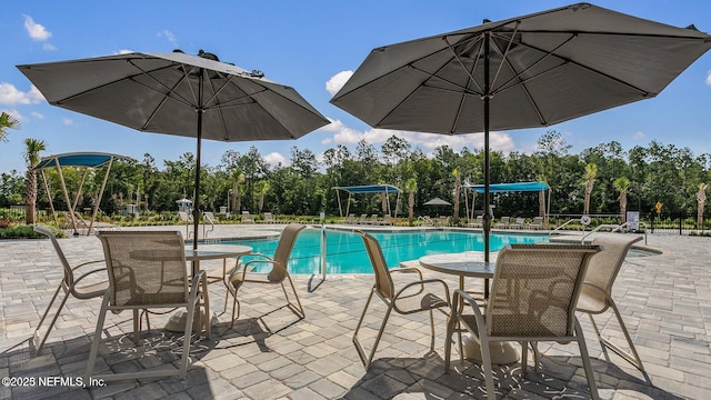 community pool with fence and a patio