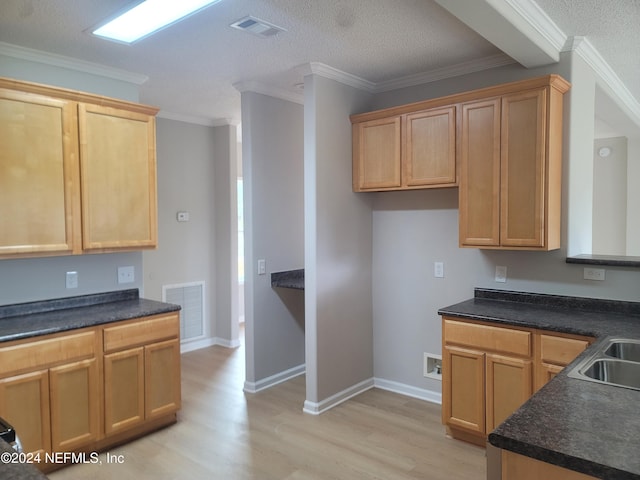 kitchen with ornamental molding, a textured ceiling, and light hardwood / wood-style floors