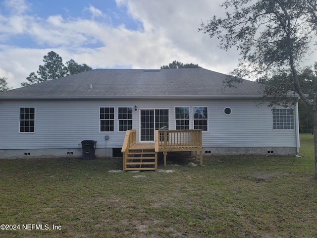 rear view of house with a yard and a deck