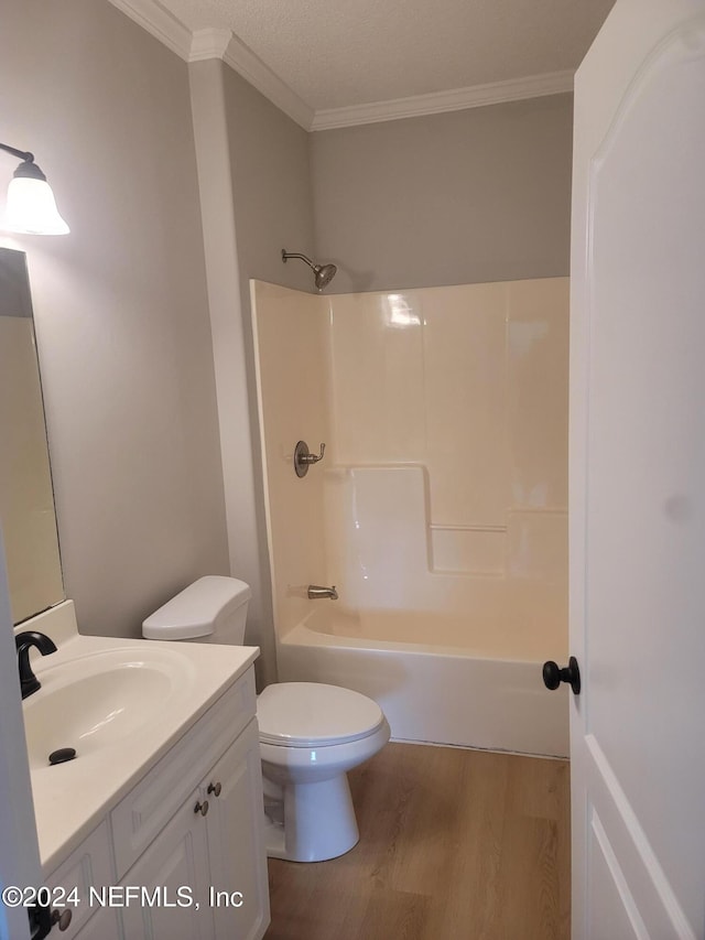 full bathroom with  shower combination, hardwood / wood-style floors, toilet, vanity, and crown molding