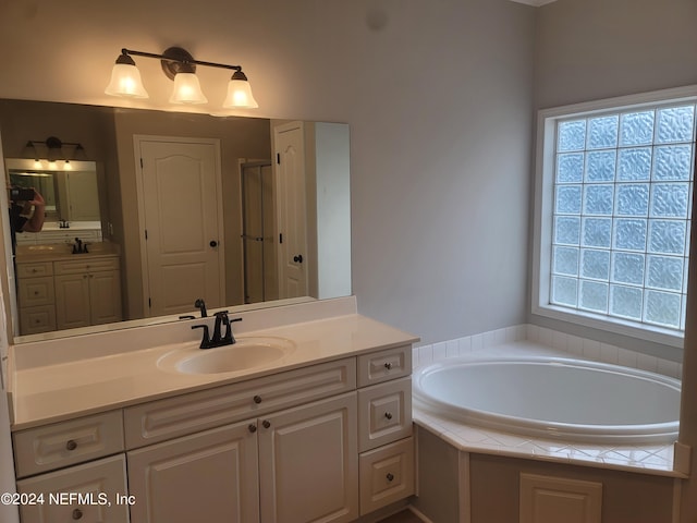 bathroom with vanity and independent shower and bath