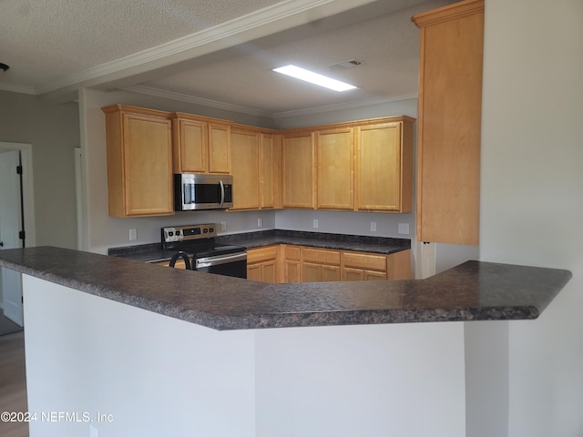 kitchen with appliances with stainless steel finishes, kitchen peninsula, and ornamental molding