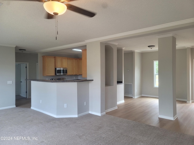 kitchen with kitchen peninsula, ornamental molding, and a textured ceiling