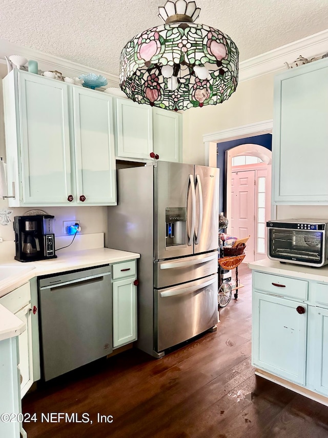 kitchen with dark wood-type flooring, crown molding, stainless steel appliances, and a textured ceiling