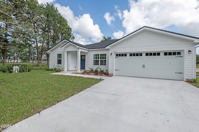 ranch-style house featuring a garage and a front lawn