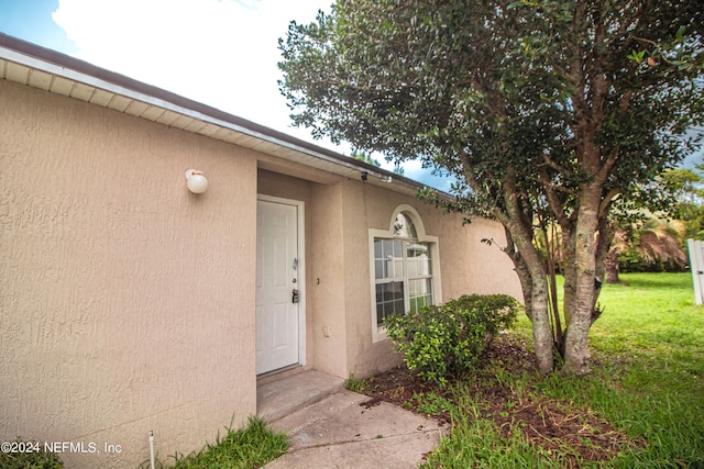 entrance to property with a lawn