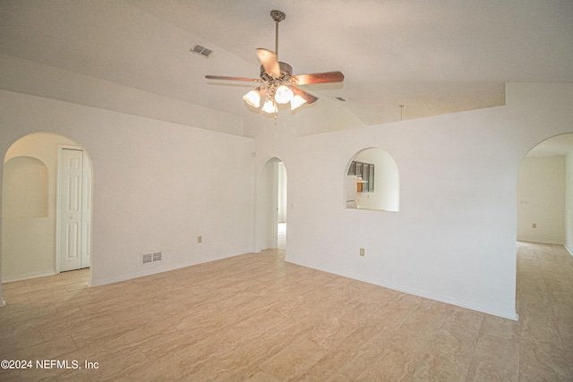 spare room with vaulted ceiling, light wood-type flooring, and ceiling fan