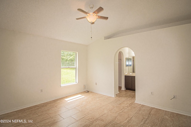 unfurnished room with lofted ceiling, a textured ceiling, and ceiling fan