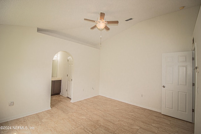 spare room with ceiling fan, a textured ceiling, and lofted ceiling