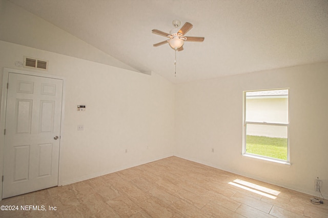 unfurnished room featuring a textured ceiling, ceiling fan, and vaulted ceiling