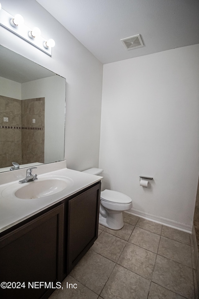 bathroom with vanity, toilet, and tile patterned flooring