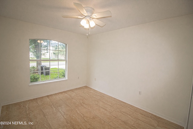 empty room with a textured ceiling and ceiling fan