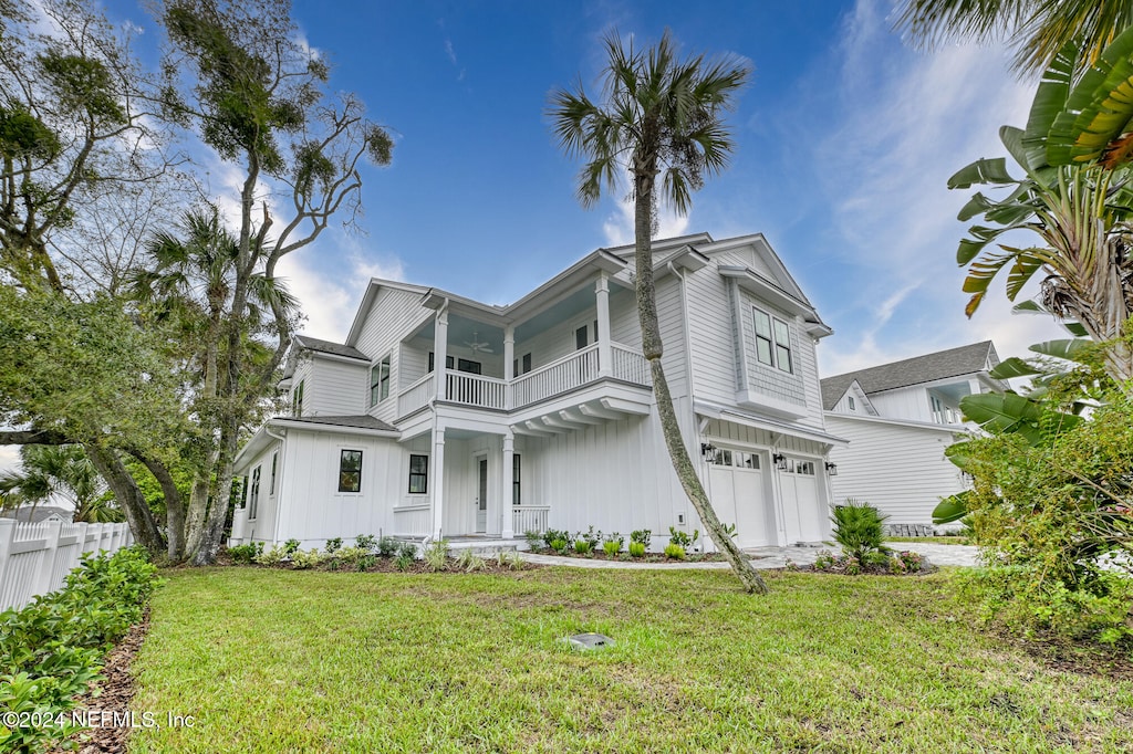 view of front of house with a front yard, a balcony, and a garage