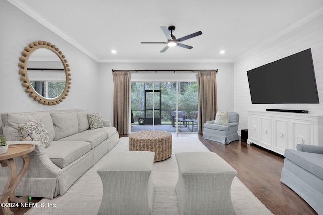 living room with ornamental molding, dark wood-type flooring, and ceiling fan