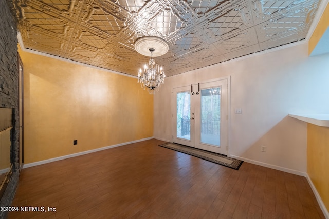 entryway featuring ornamental molding, french doors, wood-type flooring, and a chandelier