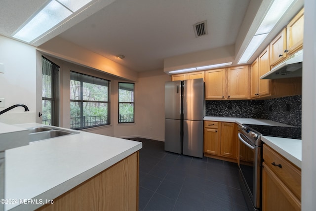 kitchen with light brown cabinetry, appliances with stainless steel finishes, sink, and decorative backsplash