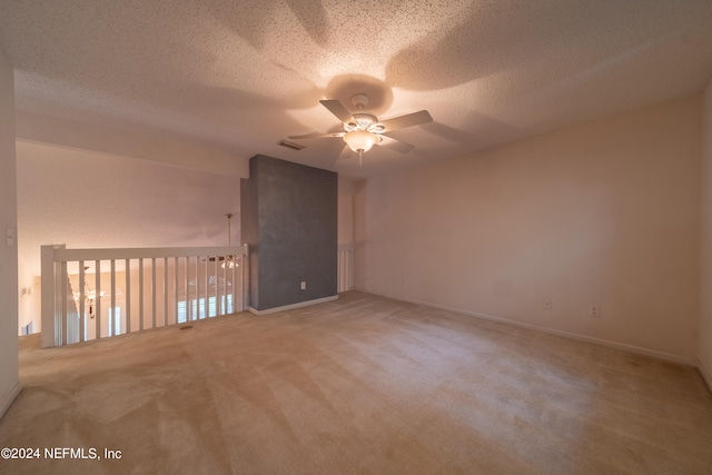 carpeted empty room with ceiling fan and a textured ceiling