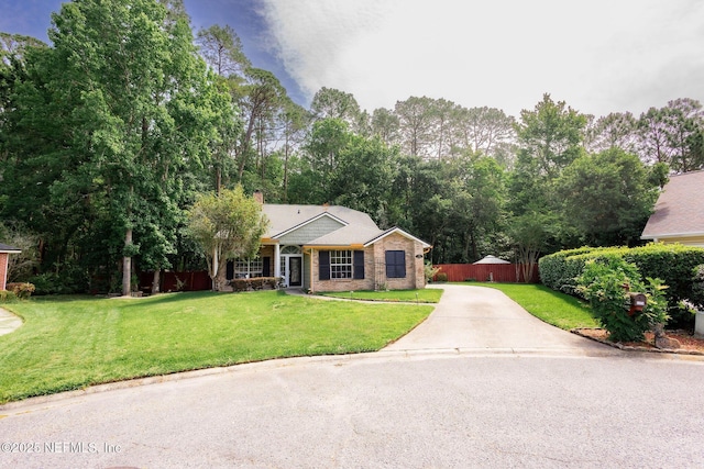 view of front facade featuring fence, a front lawn, and concrete driveway
