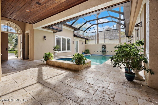 view of swimming pool featuring an in ground hot tub, glass enclosure, and a patio area