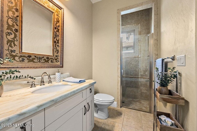 bathroom with tile patterned floors, vanity, toilet, and a shower with door