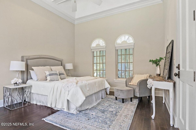 bedroom featuring ceiling fan, crown molding, dark wood-type flooring, and a high ceiling