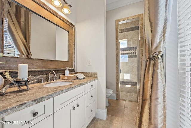 bathroom featuring tile patterned floors, a shower with door, vanity, and toilet