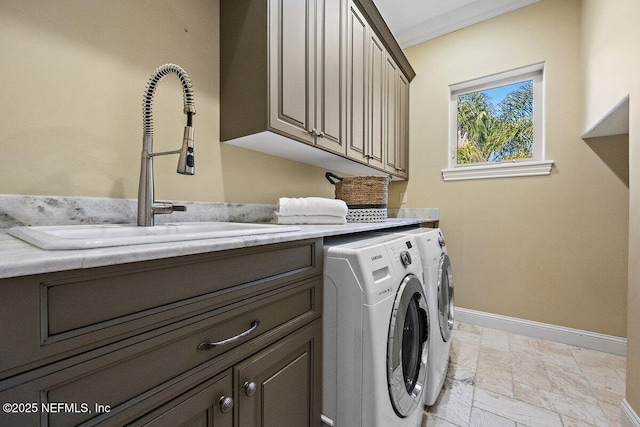 washroom featuring washer and dryer, sink, cabinets, and ornamental molding