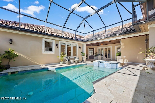 view of pool featuring glass enclosure, french doors, ceiling fan, an in ground hot tub, and a patio