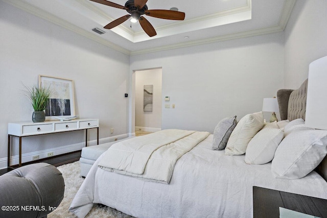 bedroom featuring ceiling fan, wood-type flooring, crown molding, and a tray ceiling