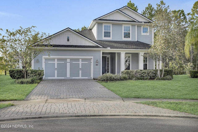 145 Sugar Sand Ln, Saint Johns, FL 32259 - view of front of house with a shingled roof, a garage, board and batten siding, a front yard, and decorative driveway