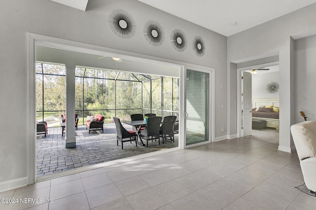 doorway with ceiling fan and light tile patterned floors