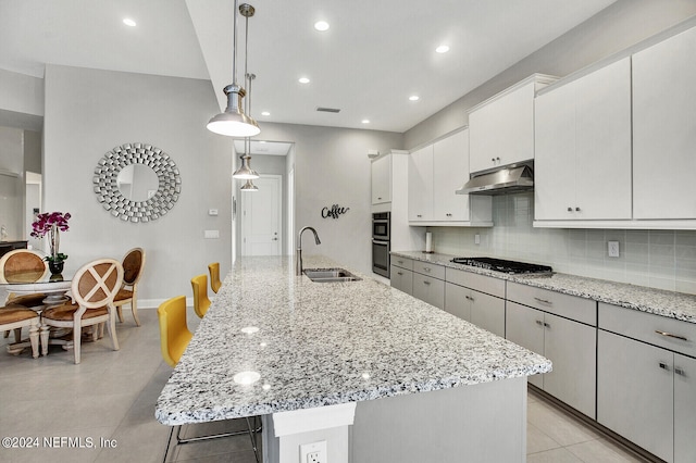 kitchen with a center island with sink, white cabinetry, sink, pendant lighting, and stainless steel appliances